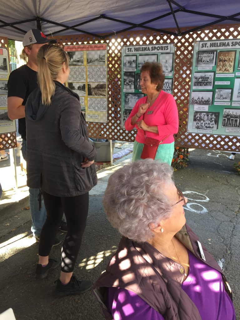 Festival-goers viewing historical photo panels at the St. Helena Historical Society booth
