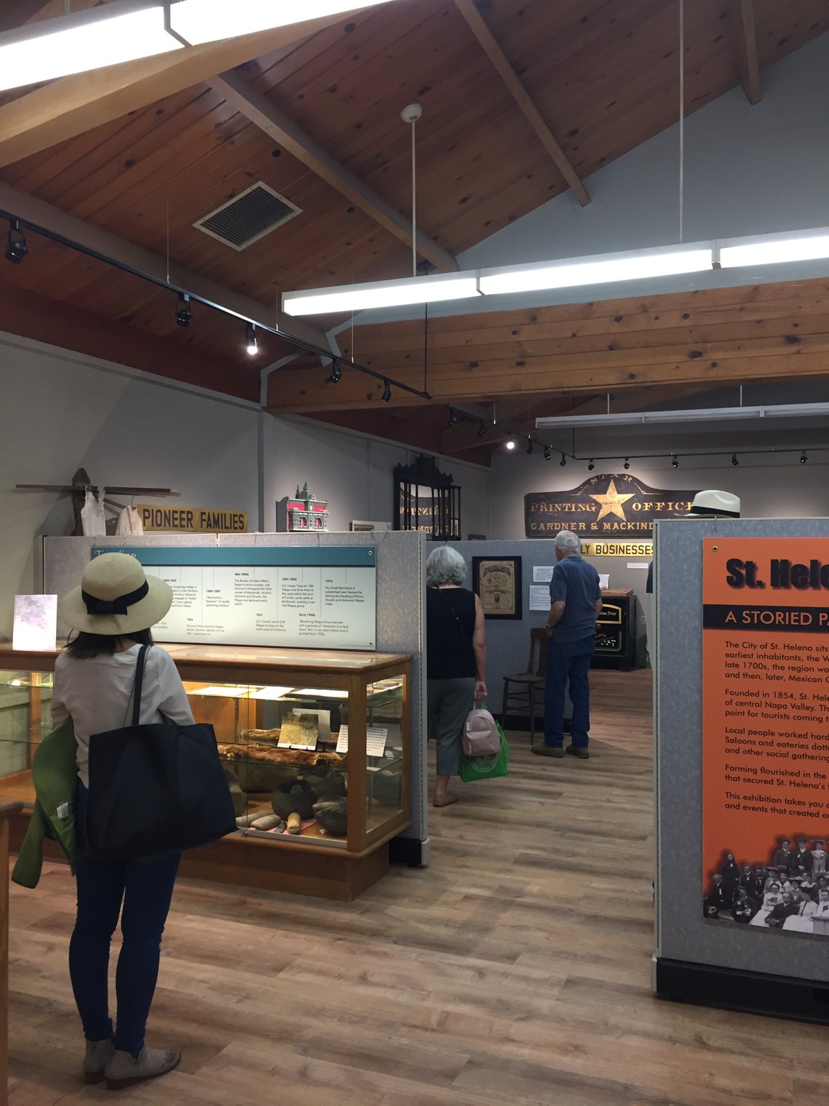 Wide view of the Heritage Center gallery with exhibit panels, display cases and visitors.